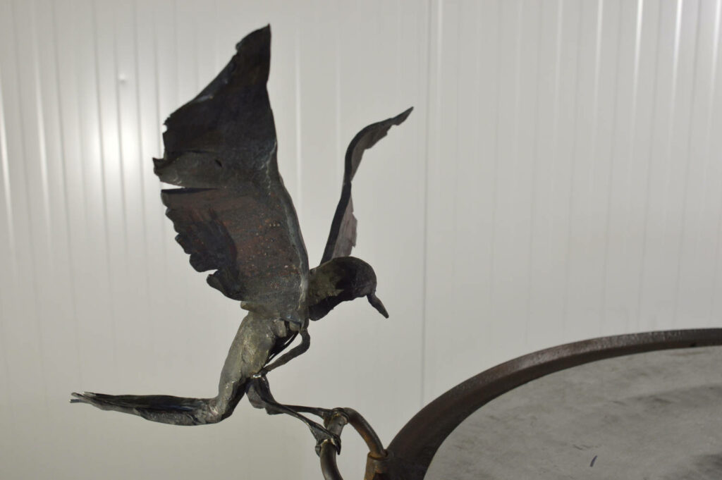 Sculpture d'oiseaux et d'une grenouille posés sur un bassin en fonte recouver d'une coupe en acier inox martelé.